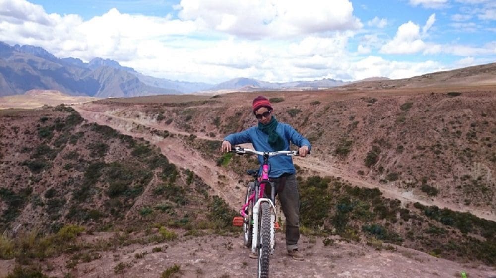 Sacred Valleyという丘陵地帯でマウンテンバイクに乗って周遊したときに山道を背景に、マウンテンバイクと一緒に撮影した写真