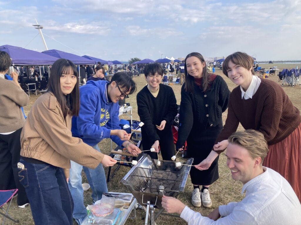 6人の東京の社員がマシュマロをやいている写真です。
