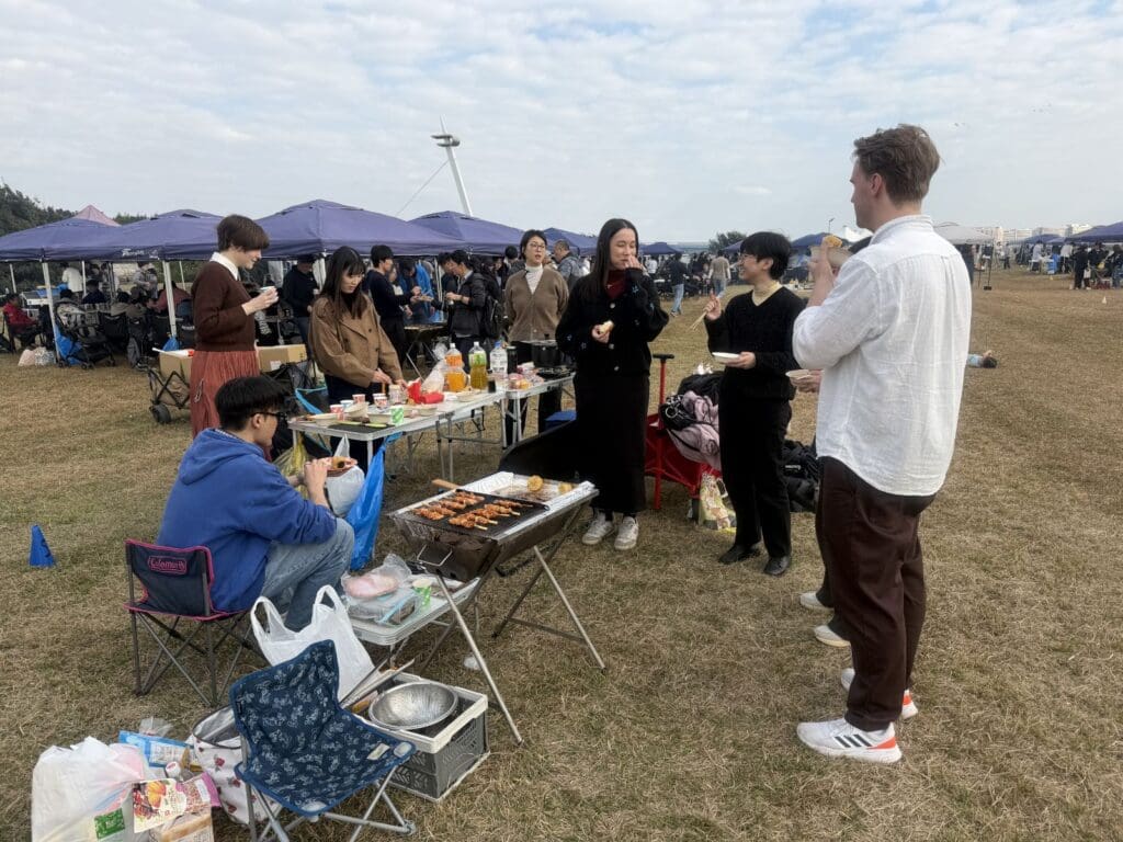 7人の社員がバーベキューをしながら、話をしている様子