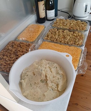奥からドレッシング、焼く前のマカロニチーズ、スイートポテトキャセロール、マッシュポテトがテーブルに載せられている