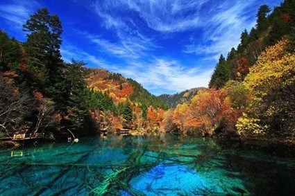 九寨溝の写真。紅葉が美しい山に囲まれたエメラルドグリーンに透き通った湖。