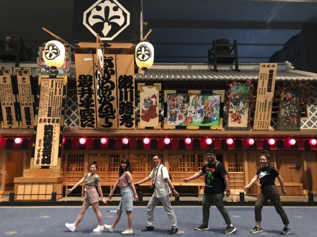 中村座の前で「ナンバ歩き」を真似する先生と学生たち