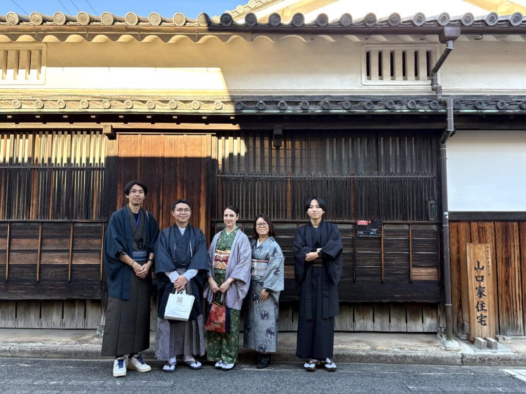遠景で5人全員で町屋にならんで木尾の姿を撮影