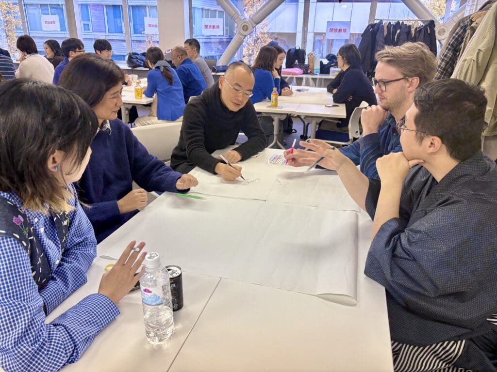 4人が一つのテーブルを囲んでディスカッションしています。