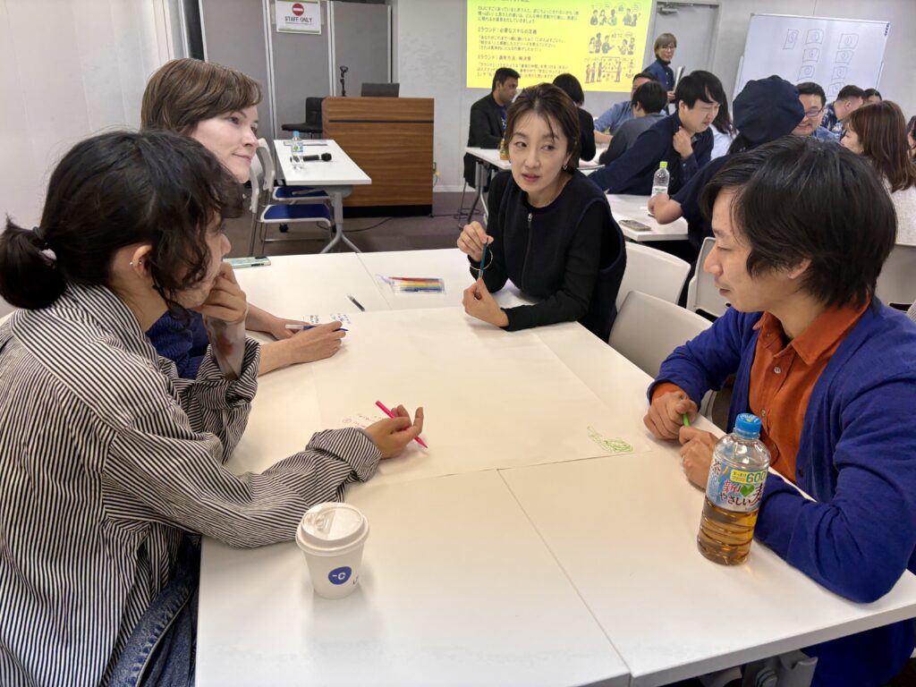 4人が一つのテーブルを囲んでディスカッションしています。