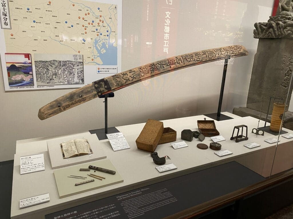 文具セット、弁当箱、羅針盤など、リニューアル後の聖地巡礼に関する展示物。