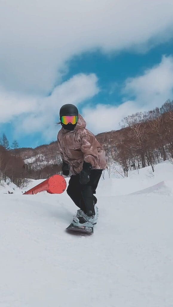 スキー場のパークでジブアイテムに入った女性のスノーボーダーです。