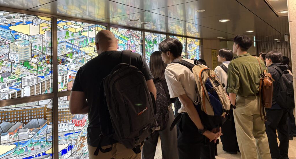 ステンドガラスの前で複数の人が鑑賞をしています。