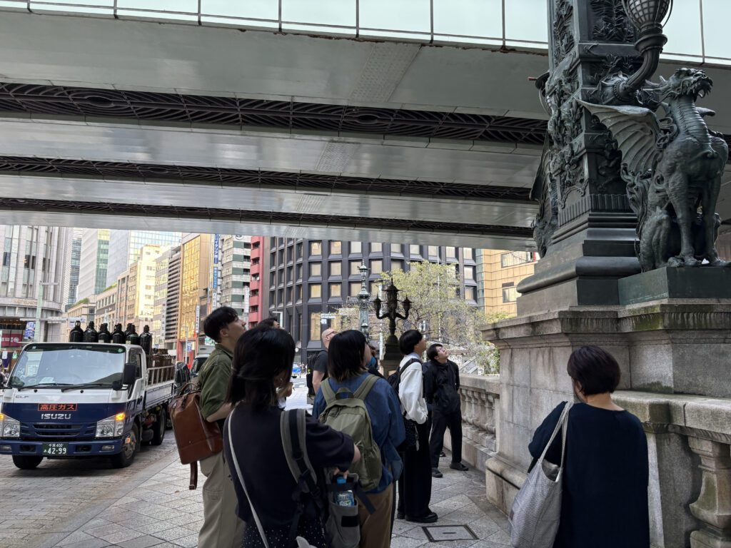 東京日本橋の麒麟像の前で複数の人が鑑賞をしています。