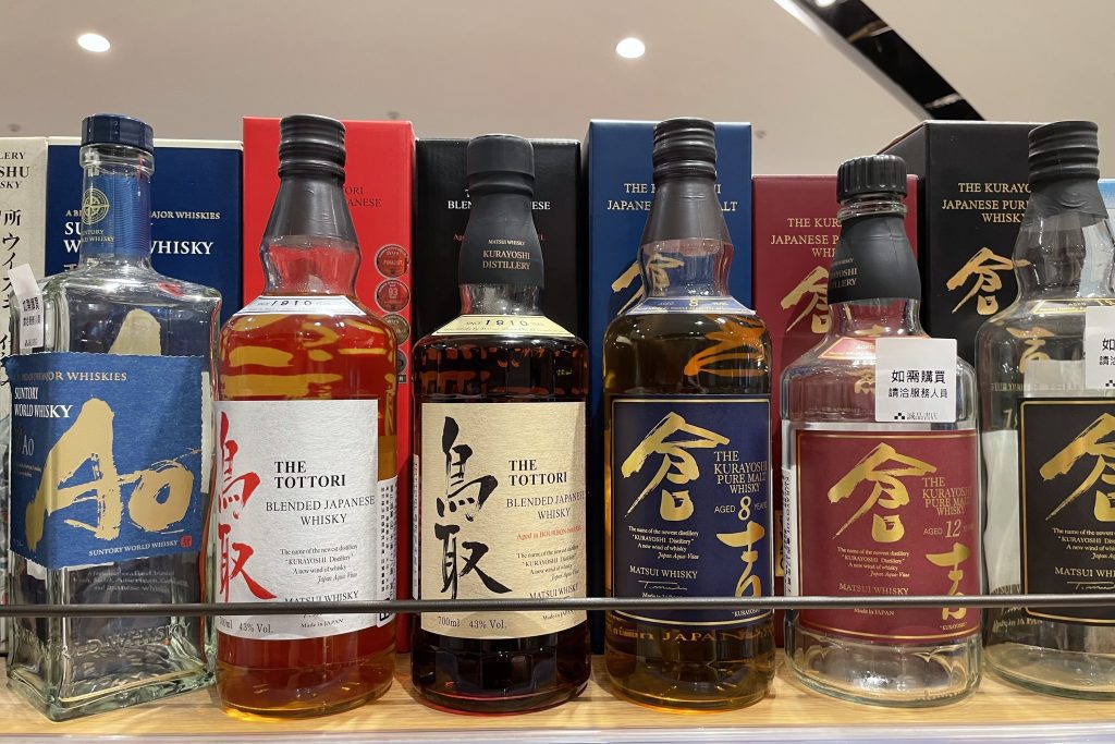 日本の蒸留酒などの瓶が６本ならんでいます。左からAo、鳥取、倉吉トラベルに文字が書かれています。