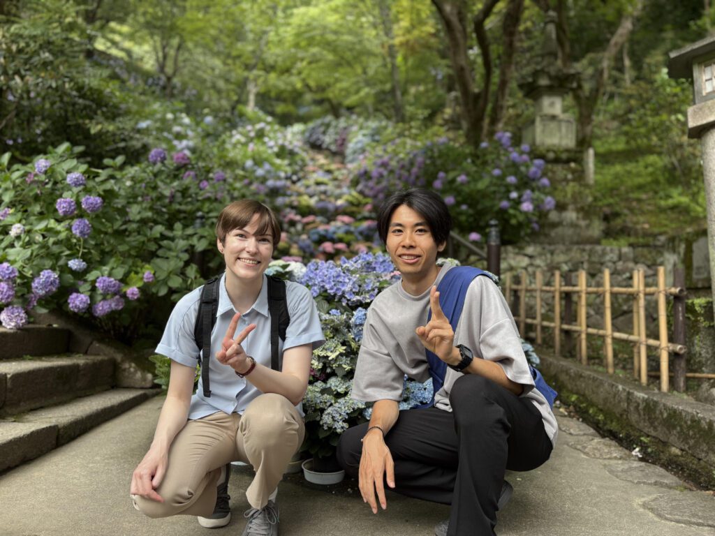 奈良県にある長谷寺の石段に設置された紫陽花の前で二人のスタッフが並んでいる様子