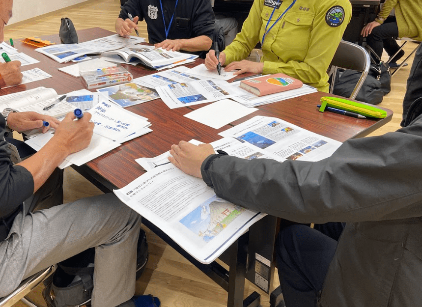 阿蘇エリアで、参加者がアイデアをたくさんの紙に書き出している様子