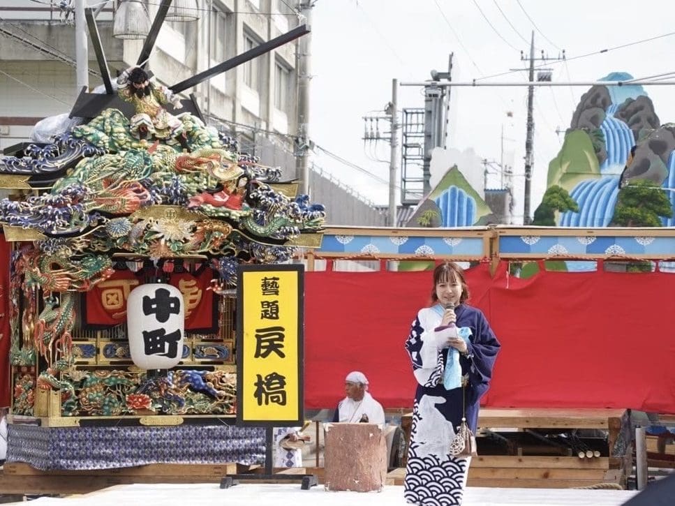 地元のお祭りに参加し概要を説明するスピーチを行っている写真