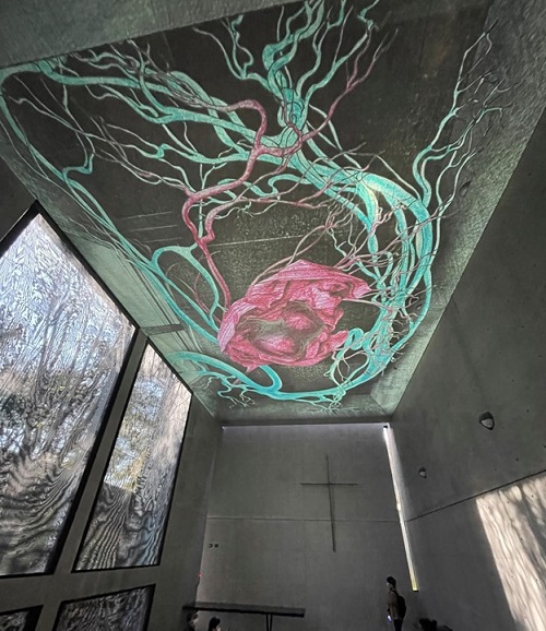 教会の天井にプロジェクションアートで赤い心臓と心臓を取り巻く緑の血管が映し出されている。